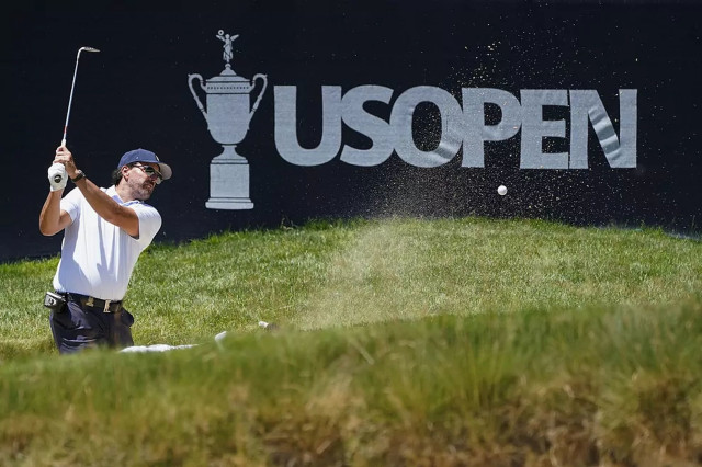Golfer hitting bunker shot US Open.
