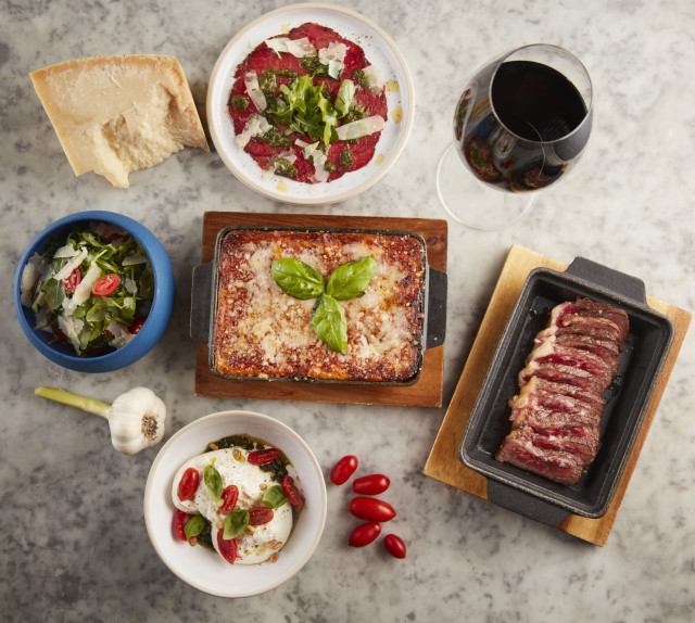 Italian dishes and wine on a marble table.