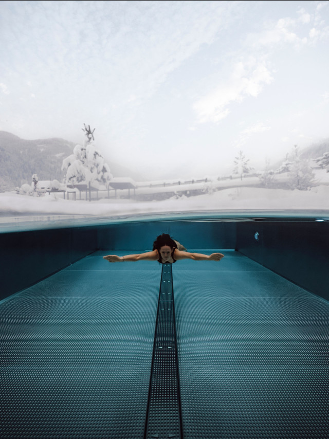 Woman swimming, snowy landscape.