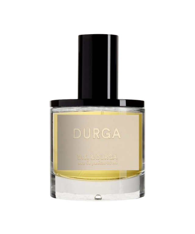 A cylindrical perfume bottle with a black cap displays a label reading 