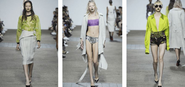 Three models walk down a runway