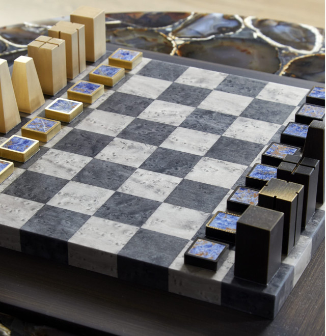 A modern chess set with rectangular pieces stands on a marble-patterned board