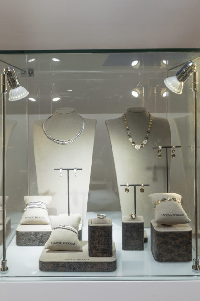 Jewelry displayed in a glass case with MARCO BICEGO branding.