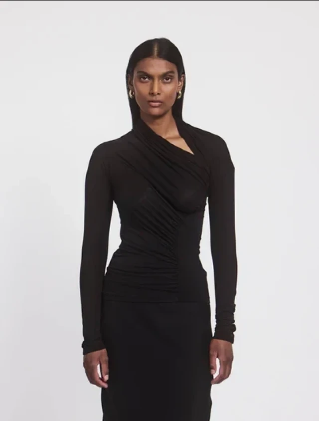 Model in black draped top.