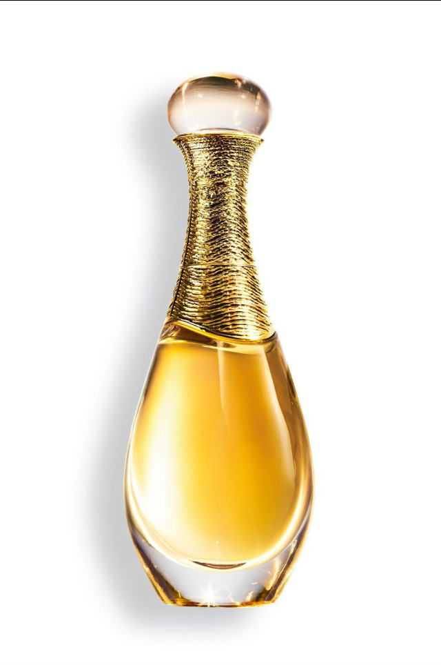 A gold-capped perfume bottle with a clear, curvy design holds amber liquid, set against a white backdrop, conveying elegance and luxury