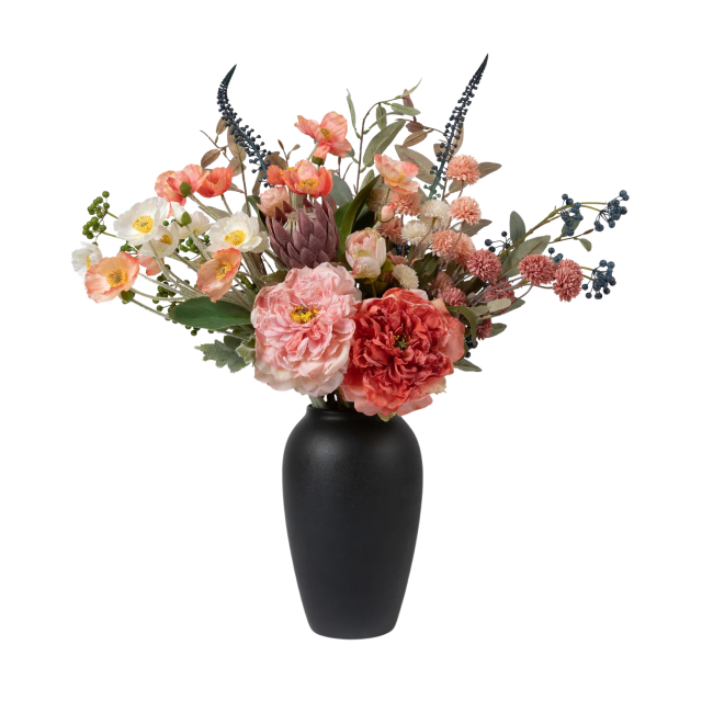 Black vase with artificial flowers on white.
