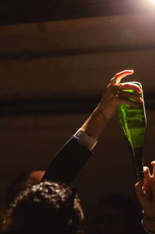 Bottle handed in a cellar-like space.
