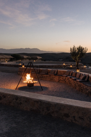 Bonfire in desert setting with stone seating.