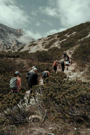 Hikers ascend mountain trail.