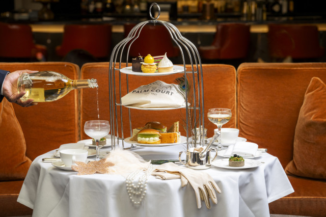 great gatsby-themed afternoon tea set-up with deep orange velvet sofa in the background