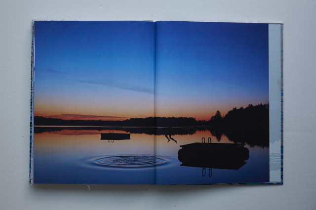 Person diving into a lake at sunset