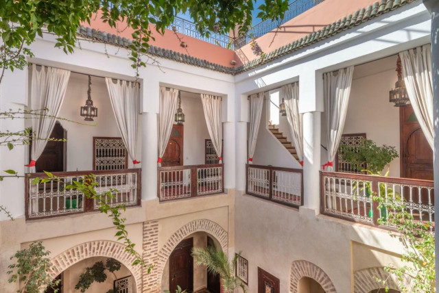 White building with balconies around a courtyard.