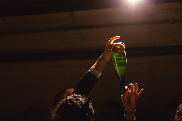 Bottle handed in a cellar-like space.