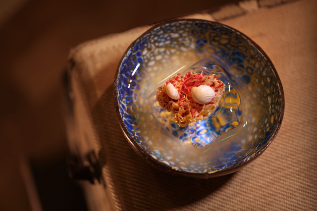 Bowl with a yellow-red confection and shells.