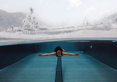 Woman swimming, snowy landscape.