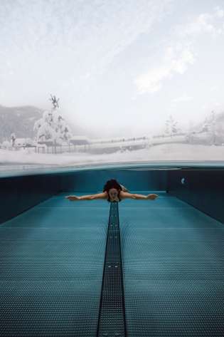 Woman swimming, snowy landscape.