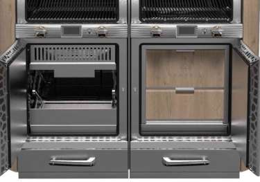 Dual charcoal ovens with open doors revealing compartments, situated in a commercial kitchen setting.