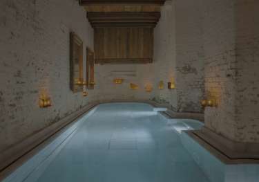 Bath inside spa with candles dotted about.
