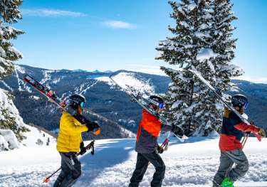 Skiers climbing mountain.