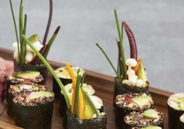 Quinoa sushi rolls with vegetables on a tray.