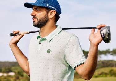 Oceantee man holding golf club on golf course .