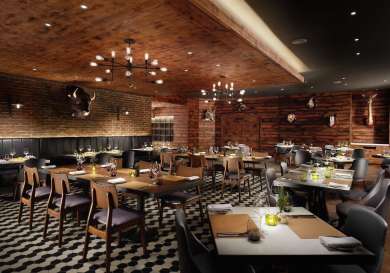 Restaurant features wooden tables and leather chairs set for dining, surrounded by brick and wood walls adorned with mounted animal heads. Warm lighting creates a cozy, rustic atmosphere.