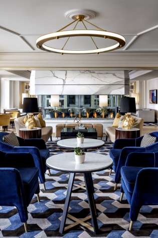 Blue velvet chairs and tables in a luxurious lounge.