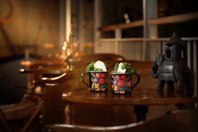 Ornate mugs with iced drinks in a dim bar.