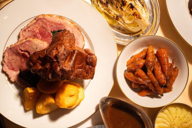 Roast beef with vegetables and cabbage sides.