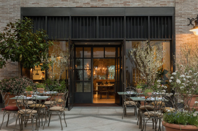 Outdoor patio with tables, chairs, and warm restaurant lighting.