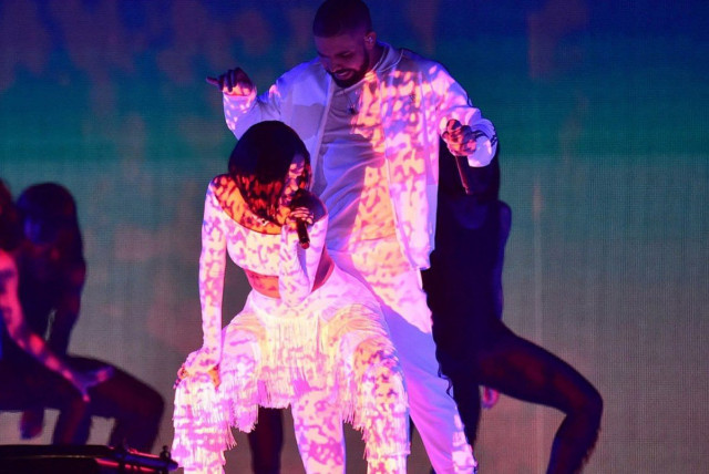 Performers singing and dancing under colored lights.