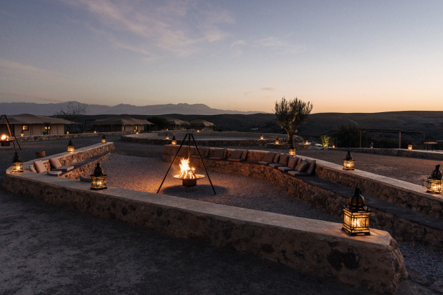 Bonfire in desert setting with stone seating.