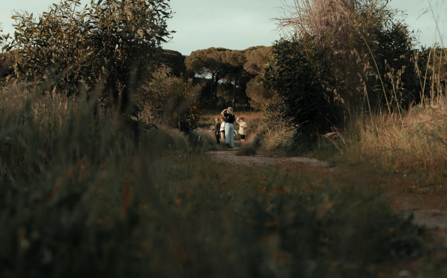 Woman and children walking on wooded path.