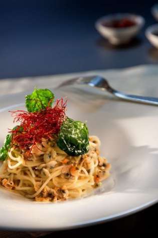 Spaghetti with clams in a restaurant setting.